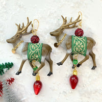 Reindeer earrings with embellished miniature reindeer in green and gold ribbon sashes and gold chain collars. Cute Christmas earrings for women.