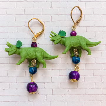 Miniature dinosaur earrings with green dinosaurs and dangling beads. Triceratops earrings for women.