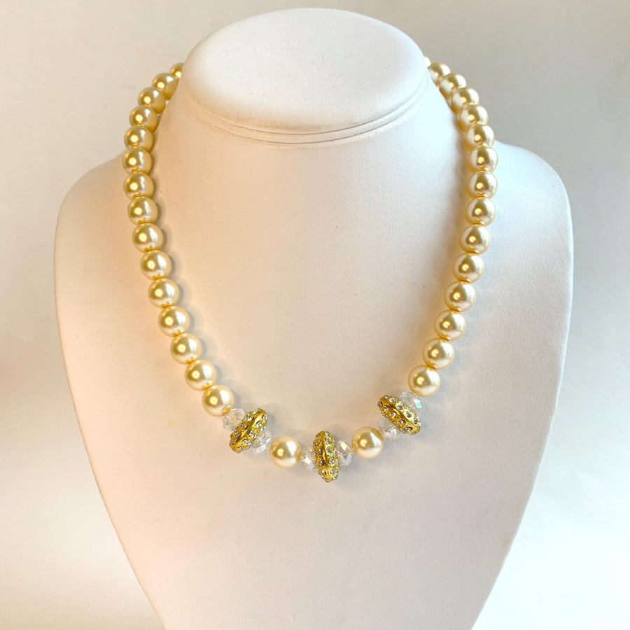 Cream pearl choker necklace for women with gold spacers embedded with rhinestones in the center. Modern traditional bridal jewellery.