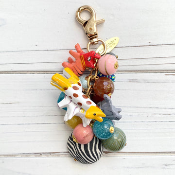 Colorful beaded beaded bag charm with wooden safari animals and gold trigger clasp.