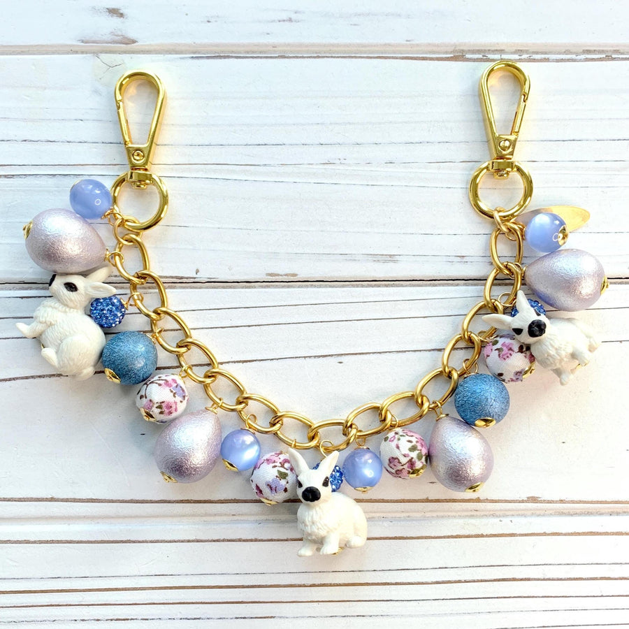 Gold bag chain with miniature white bunny charms and a mix of blue beads, fabric floral beads and silver egg shaped beads. Cute bunny bag charm chain.