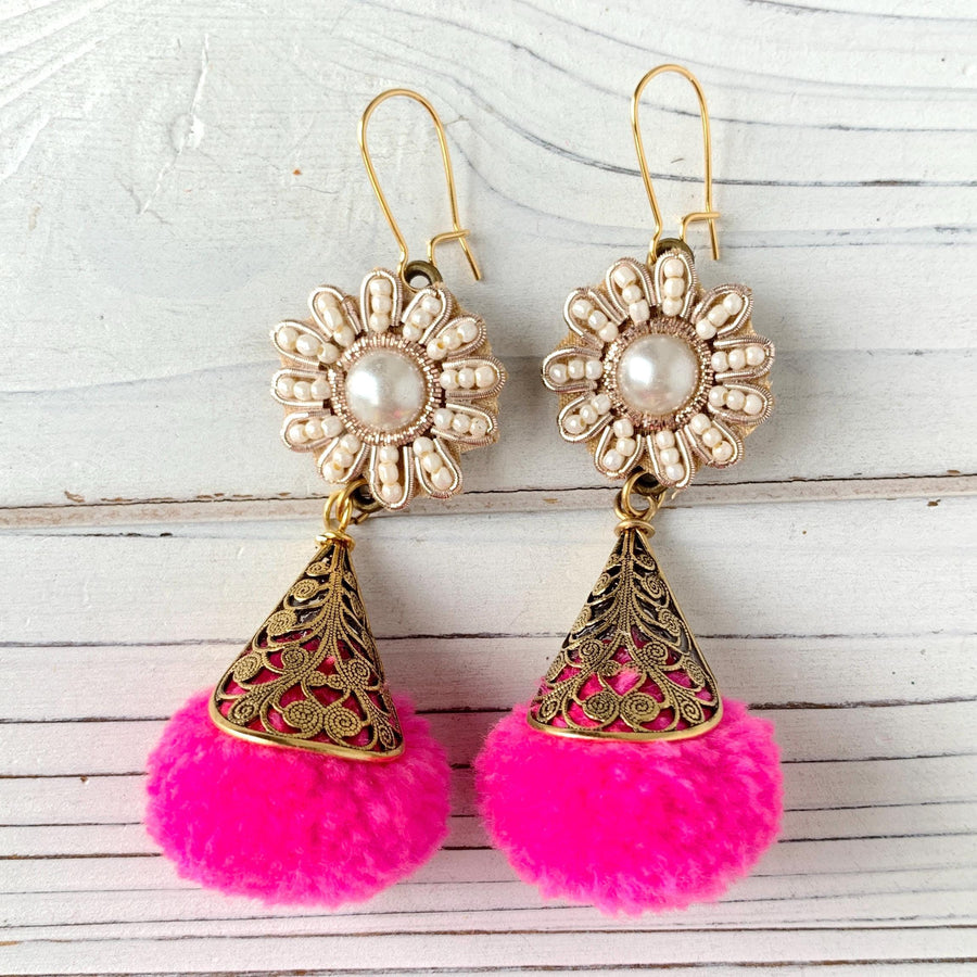 Pearl and seed bead flowers with hot pink pom pom encased in brass filigree bead caps. Cute handmade dangle earrings for women. Hot pink earrings.