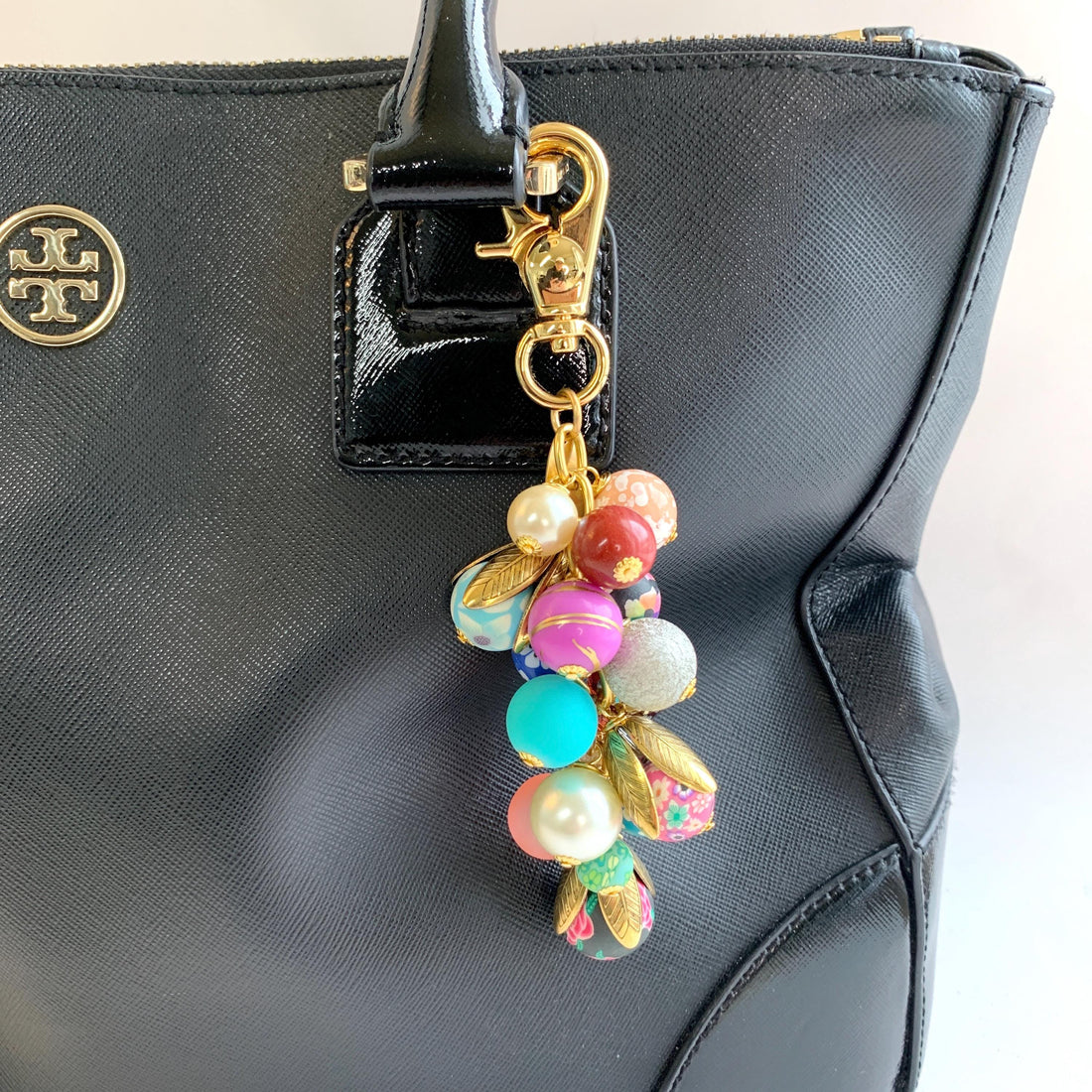 Beaded bag charm for handbags. Gold trigger clasp with long chain filled with a mix of floral beads, sparkly beads and pearls. Colorful purse charm.