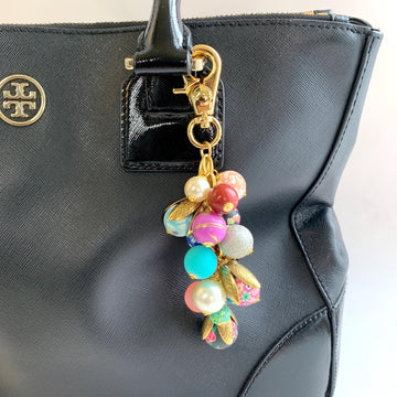 Beaded bag charm for handbags. Gold trigger clasp with long chain filled with a mix of floral beads, sparkly beads and pearls. Colorful purse charm.