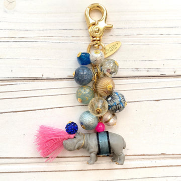 Hippo keychain with miniature hippo charm and a mix of blue and gold beads on a gold chain with gold trigger clap. Hippo bag charm for purse.