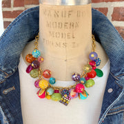 Colorful beaded necklace for women. Assorted colorful beads with different shapes and texture hung on a gold cable chain.