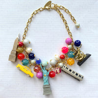 New York City charm necklace for women. New York landmark charms and assorted colorful beads on a gold chain. Funky necklaces for women.