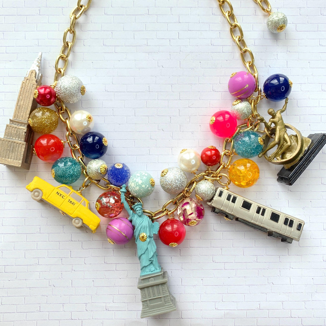 New York City charm necklace for women. New York landmark charms and assorted colorful beads on a gold chain. Funky necklaces for women.