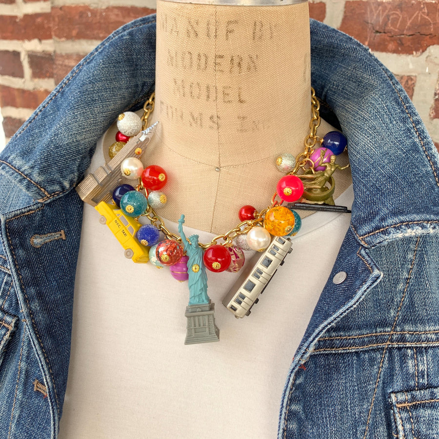 New York City charm necklace for women. New York landmark charms and assorted colorful beads on a gold chain. Funky necklaces for women.