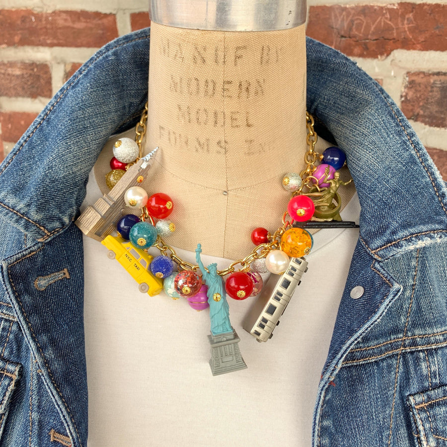 New York City charm necklace for women. New York landmark charms and assorted colorful beads on a gold chain. Funky necklaces for women.