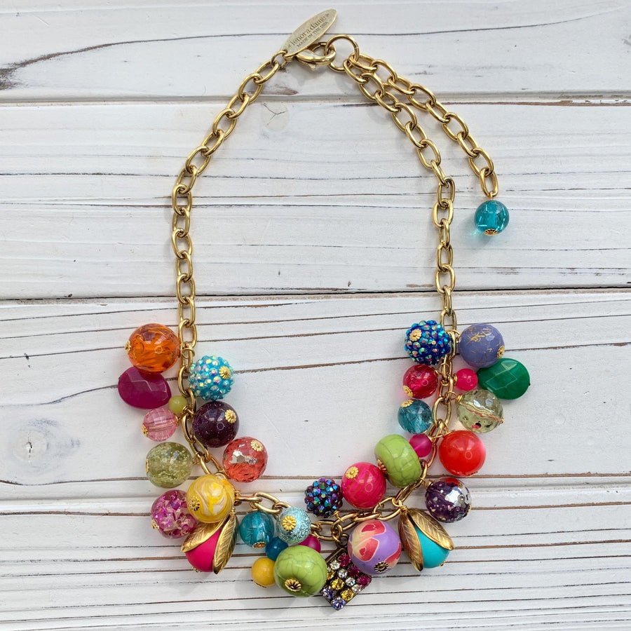 Colorful beaded necklace for women. Assorted colorful beads with different shapes and texture hung on a gold cable chain.