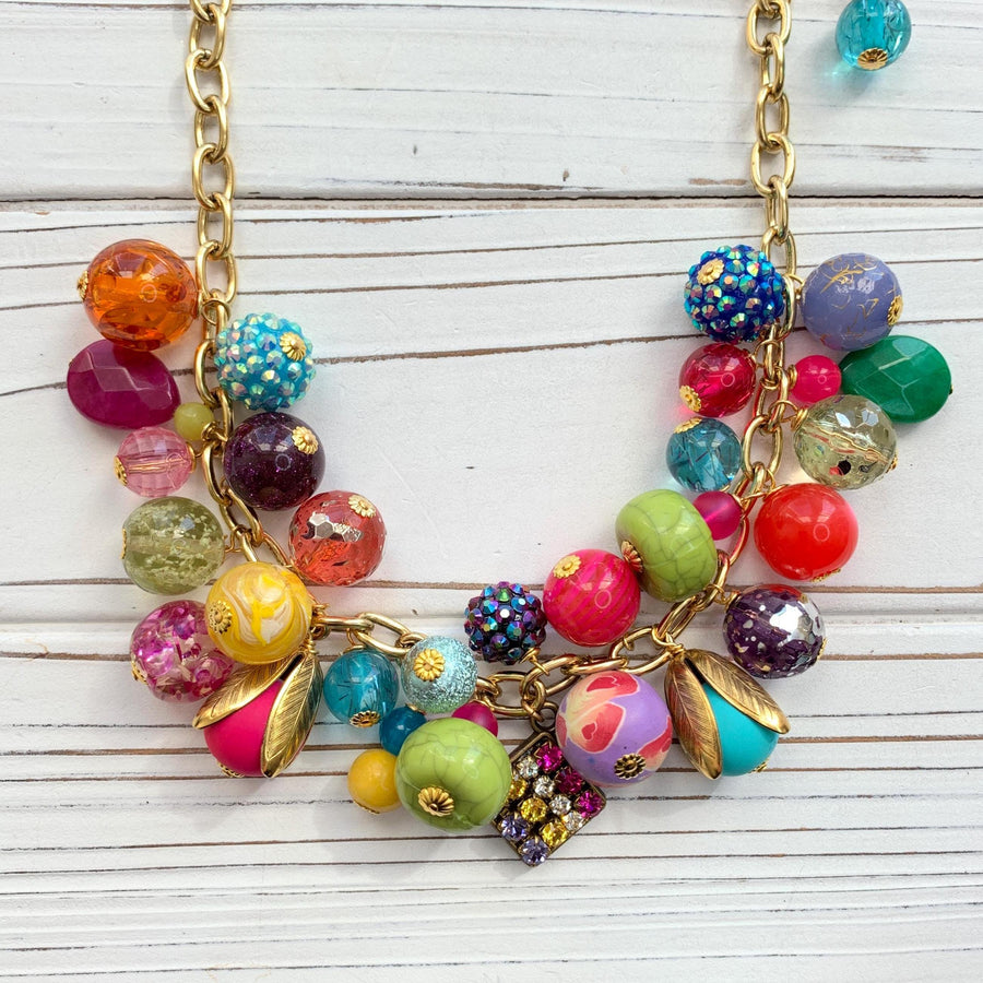 Colorful beaded necklace for women. Assorted colorful beads with different shapes and texture hung on a gold cable chain.