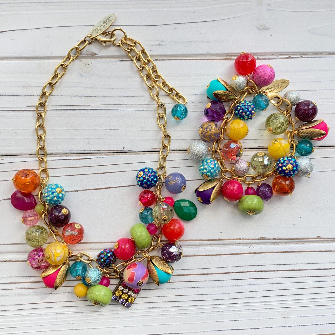 Colorful statement necklace and bracelet set for women. Assorted colorful beads with different shapes and texture hung on a gold cable chain.