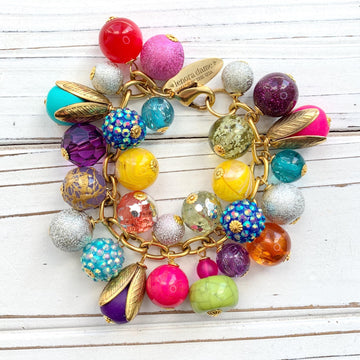 Colorful beaded bracelet for women. Assorted unique beads in a wide range for colors, texture, and shape wire wrapped on a solid and sturdy brass plated chain with lobster clasp.