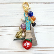 New York City bag charm . New York City keychain with colorful beads and statue of liberty charm, Prometheus charm, and Chrysler Building charm.